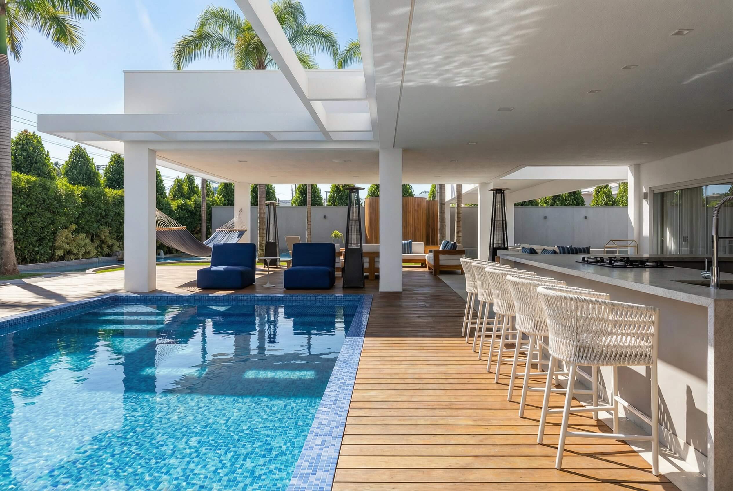 Área de lazer integrada com piscina, cozinha e deck de madeira